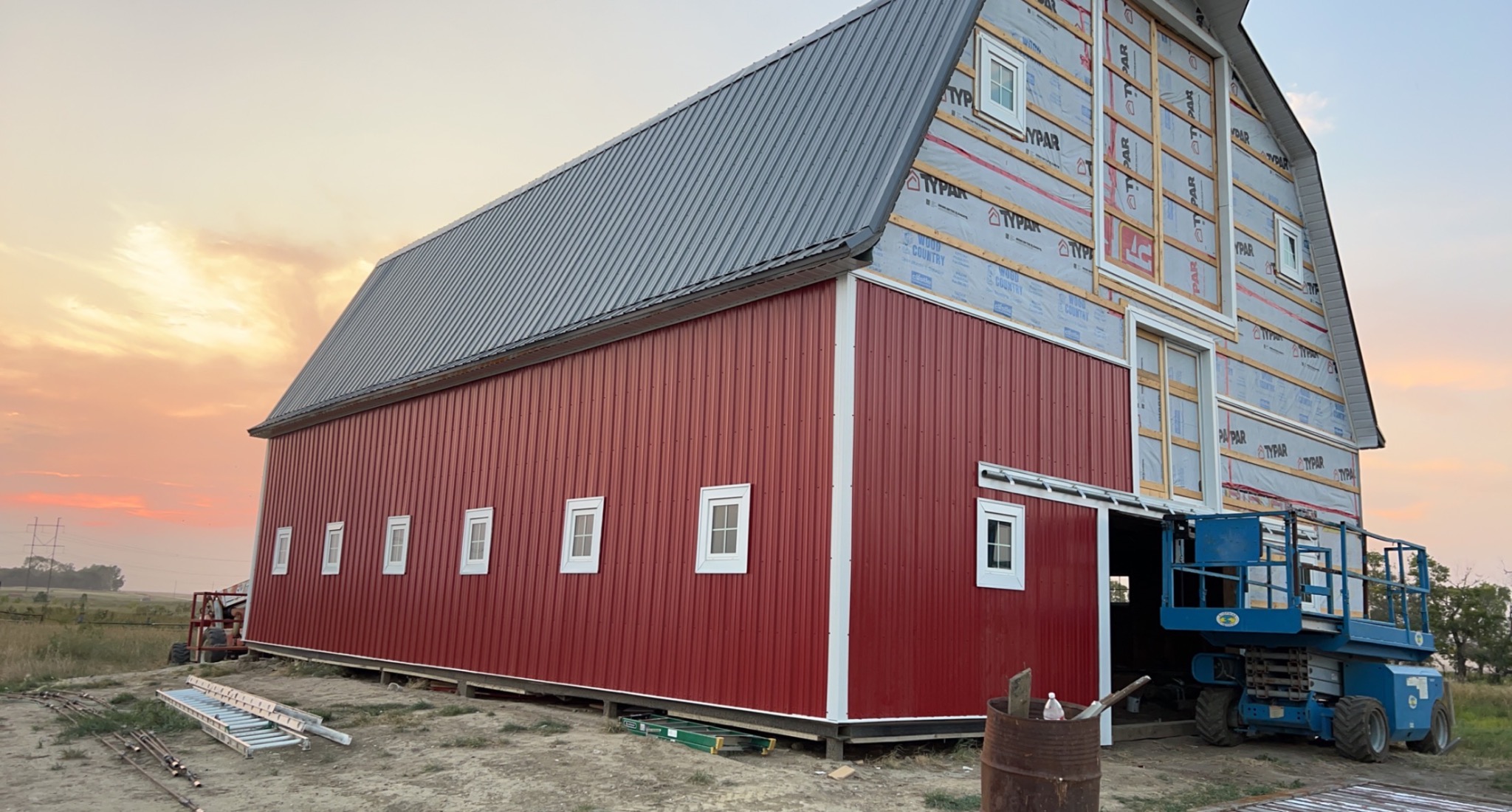 Barn exterior during Red Diamond renovation with new red metal siding in progress